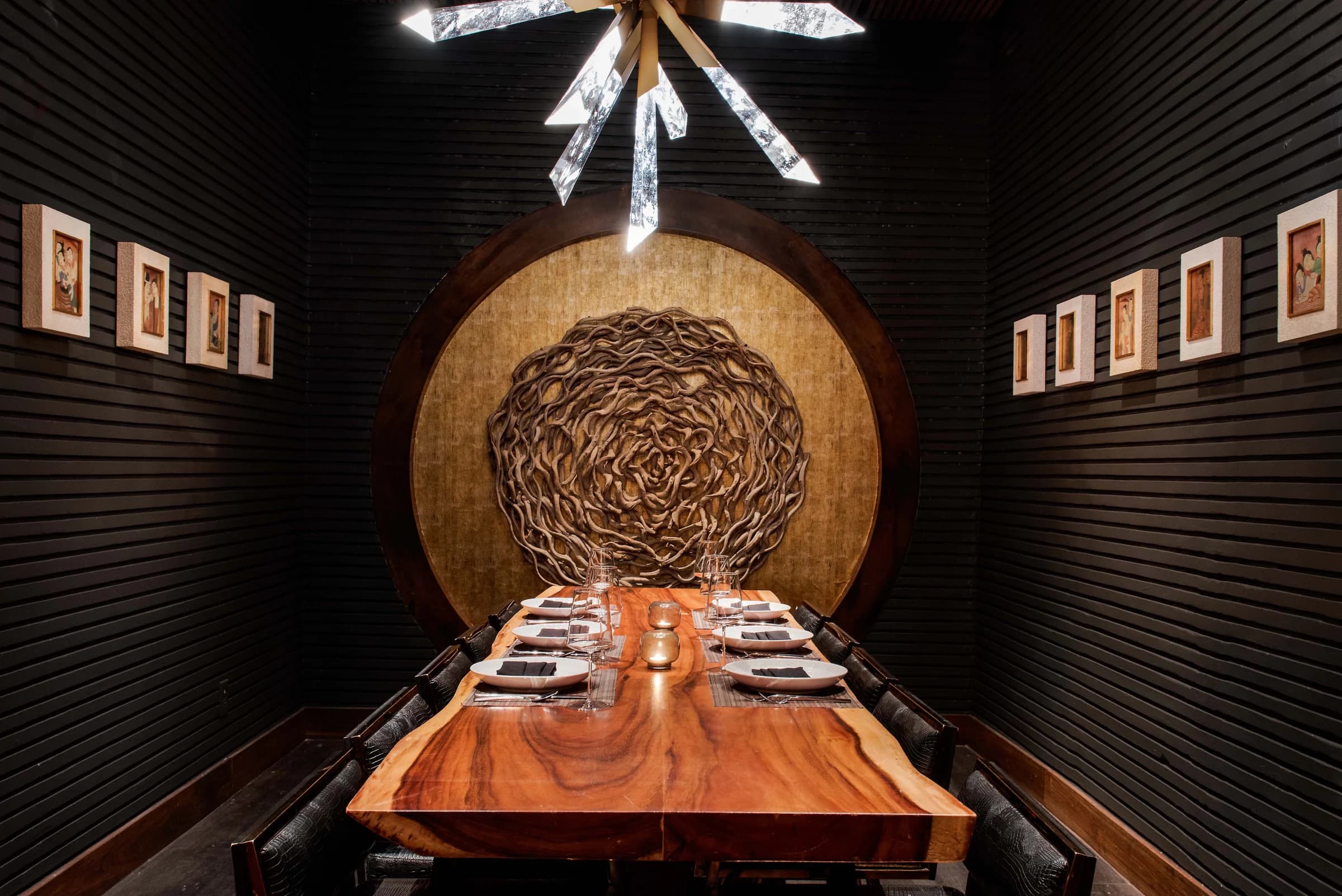 The long wood table in Charlie’s Room, set beneath a sculptural light